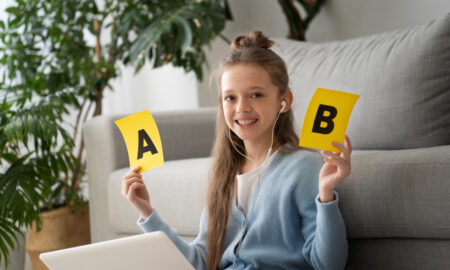 Девочка держит буквы русского алфавита на бумаге