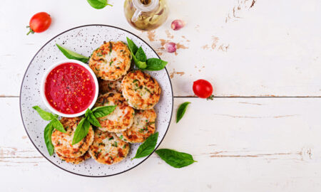 Аппетитные творожные сырники с зеленью и соусом в тарелке