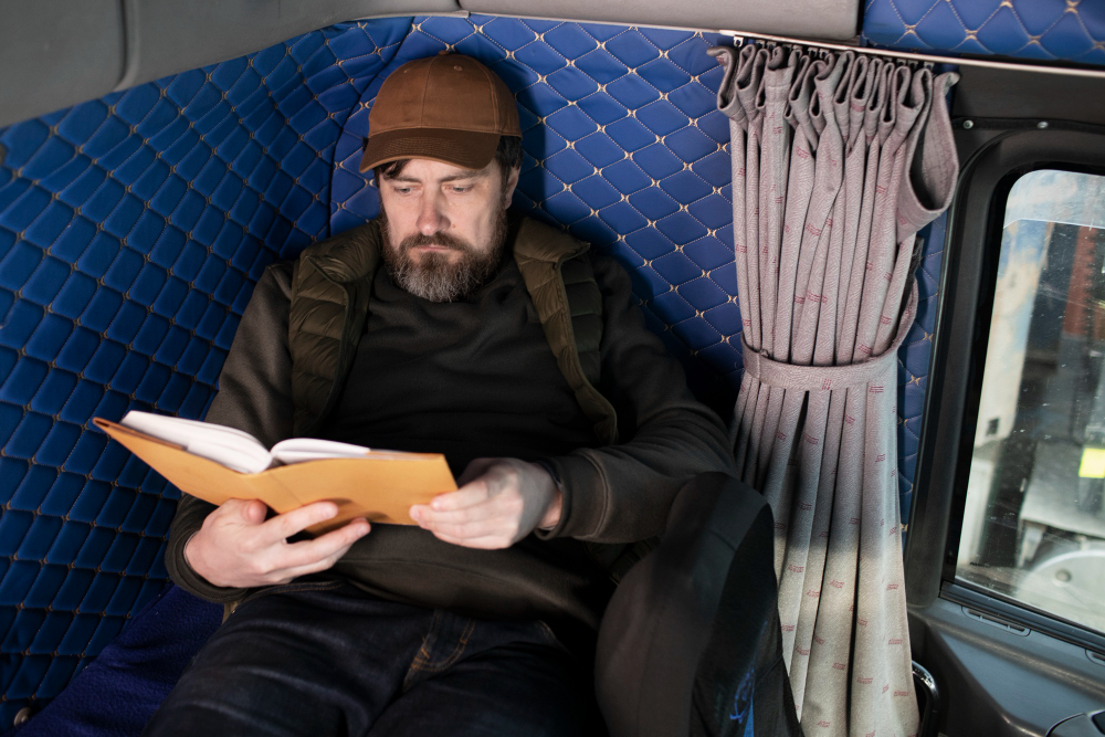 Мужчина читает книгу на полке в поезде