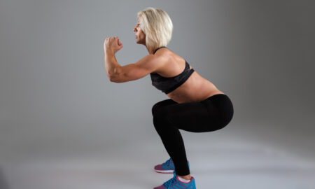 Женщина выполняет правильное приседание в профиль