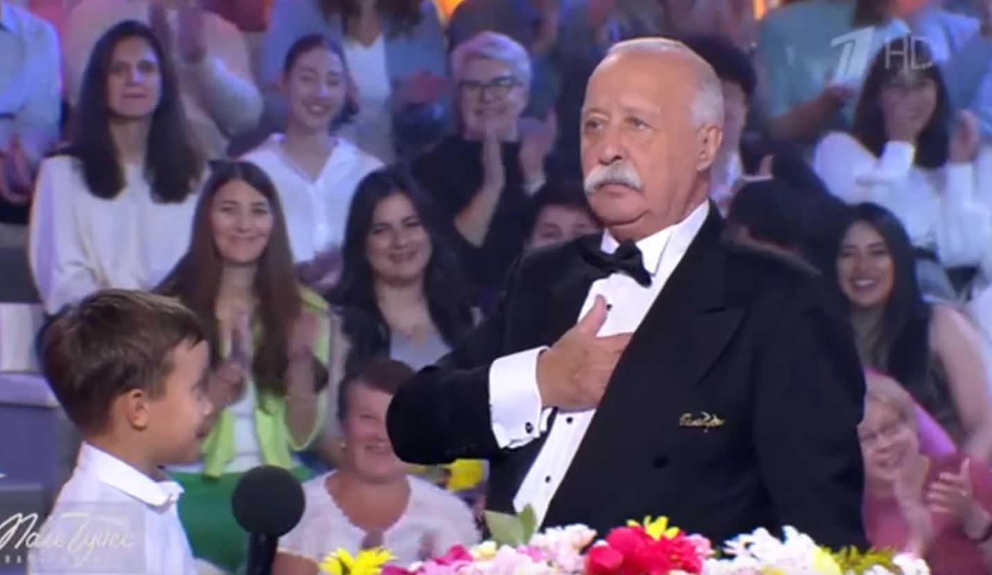 Леонид Якубович с участником у барабана в передаче «Поле чудес»