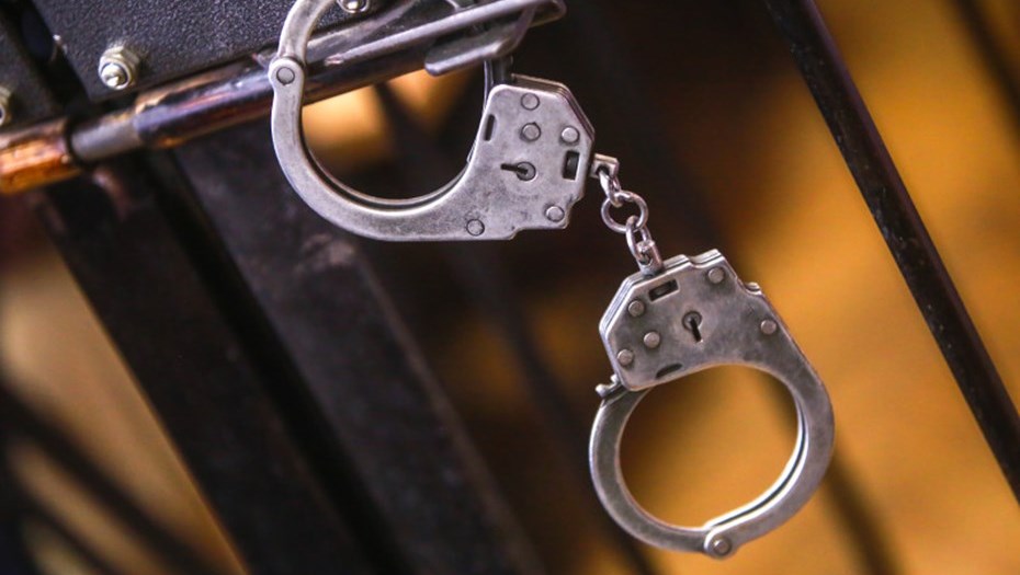 Наручники и клетка в суде.