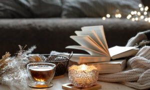 Книга возле чашки чая и свечи