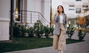 Девушка в широких штанах стоит у дома