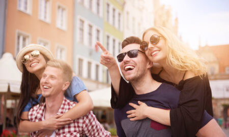 Радостная компания друзей гуляет по солнечному городу