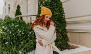 Рыжая девушка в весенней одежде на солнце