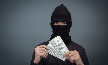 Вор стоит с кучей денег