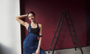 Девушка красит стены в квартире