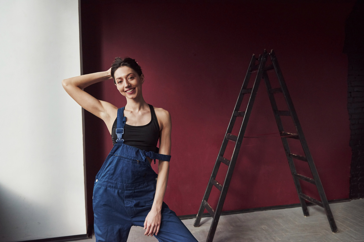 Девушка красит стены в квартире