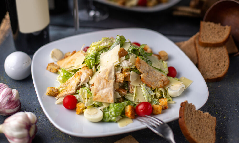 Салат с курицей и овощами лежит на тарелке