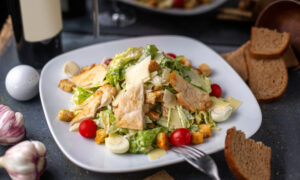 Салат с курицей и овощами лежит на тарелке