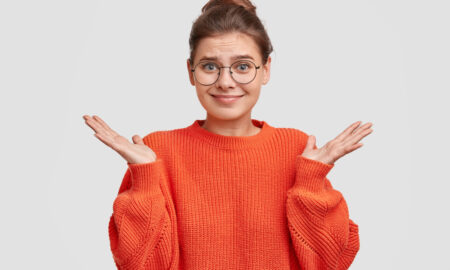 девушка в красной кофте и очках не понимает