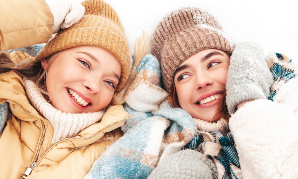 Две девушки в шапках улыбаются