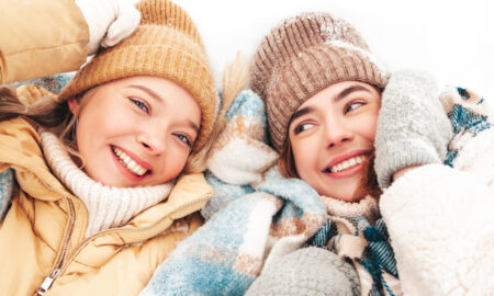 Две девушки в шапках улыбаются