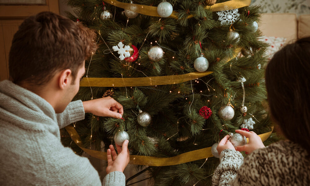 Пара наряжает новогоднее дерево