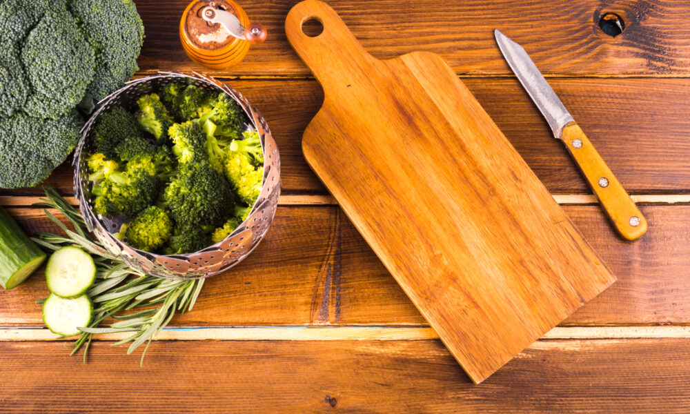 Нож возле доски и овощей