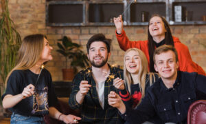 Компания друзей веселиться вместе и держат бенгальские огоньки