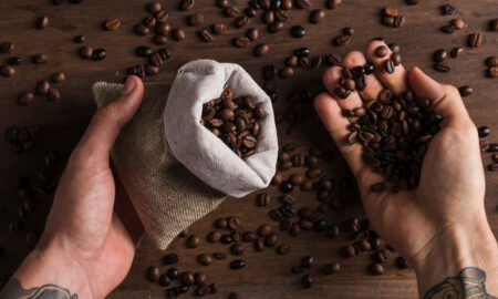 Человек держит кофейные зёрна