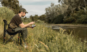 Рыбак рыбачит у водоема и ждёт улов