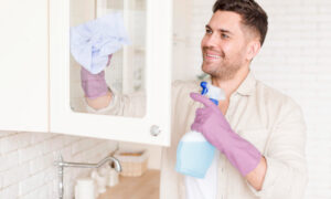 мужчина чистит стеклянные ящики