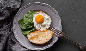 яичница со шпинатом и хлебом на тарелке