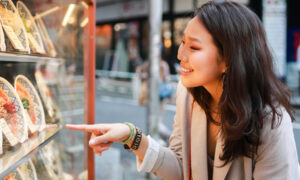 Азиатская девушка у витрины