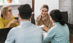 Четверо друзей и коллег общаются и смеются