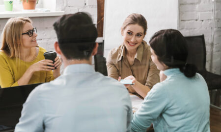 Четверо друзей и коллег общаются и смеются