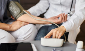 Врач меряет давление пациенту