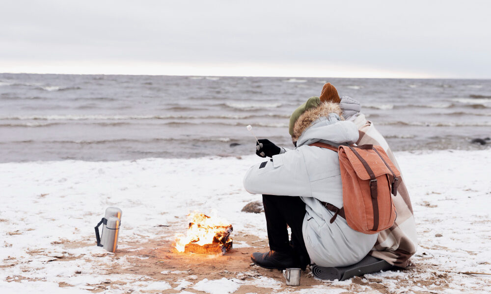 Турист сидит на пляже зимой