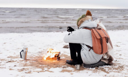Турист сидит на пляже зимой