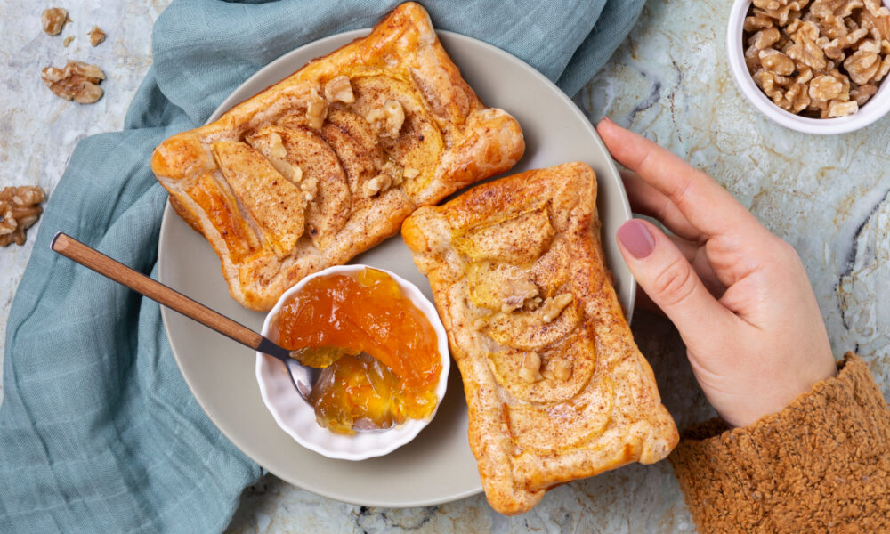 Две слойки с яблоком и миска джема