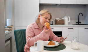 Женщина ест круассан