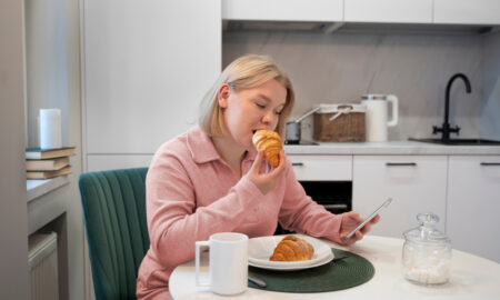 Женщина ест круассан