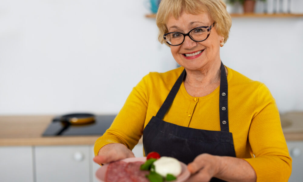 Женщина с тарелкой еды на кухне.