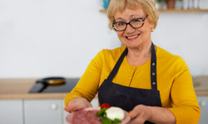 Женщина с тарелкой еды на кухне.