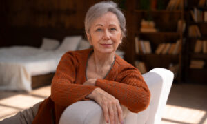 Пожилая женщина сидит на диване