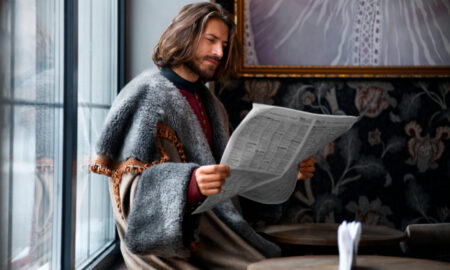 Мужчина задумчиво читает газету