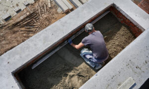 Рабочий заливает бетон