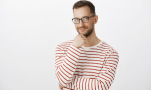 Задумчивый человек в полосатой кофте смотрит вдаль