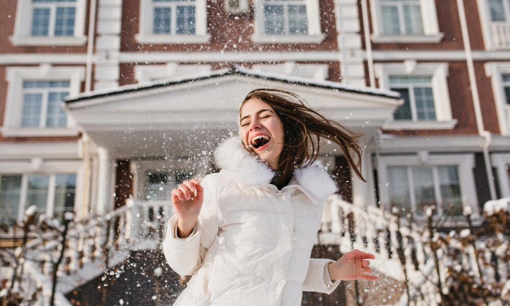 Девушка радуется на воздухе и играет со снегом