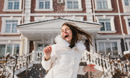 Девушка радуется на воздухе и играет со снегом