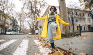 Девушка в жёлтом пальто бежит по улице