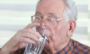 Пожилой мужчина пьет воду