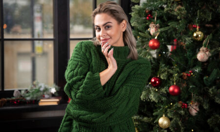 Девушка в свитере у новогодней ёлки