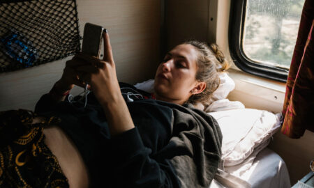 Девушка лежит на полке в вагоне поезда