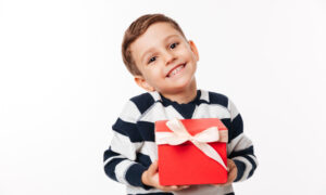 Маленький мальчик протягивает красивую коробку с бантиком