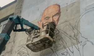 Рисуют мурал на стене.