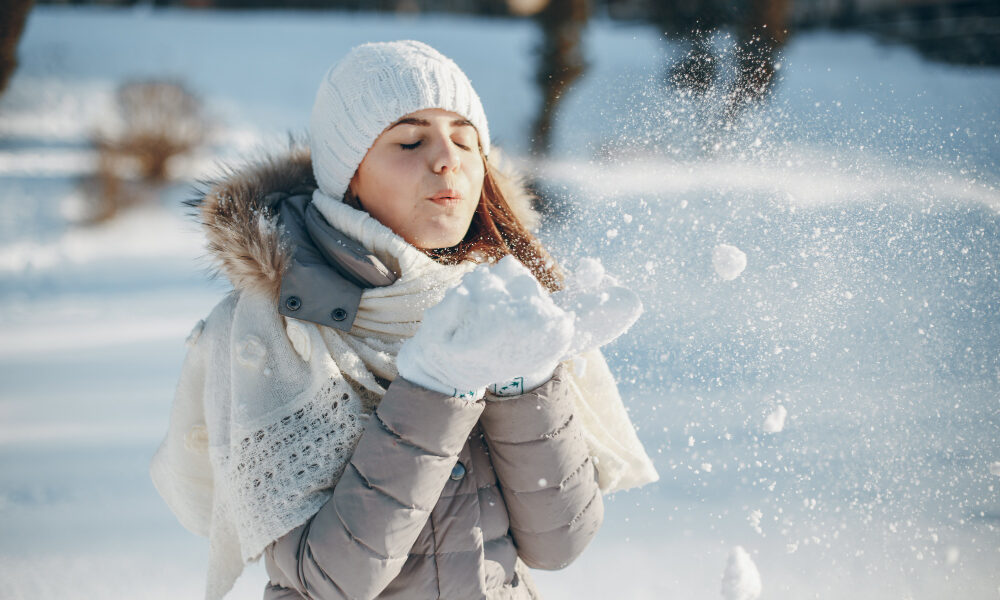 девочка играет со снегом в зимнюю погоду