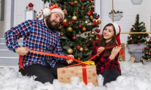 Мужчина и женщина открывают новогодний подарок